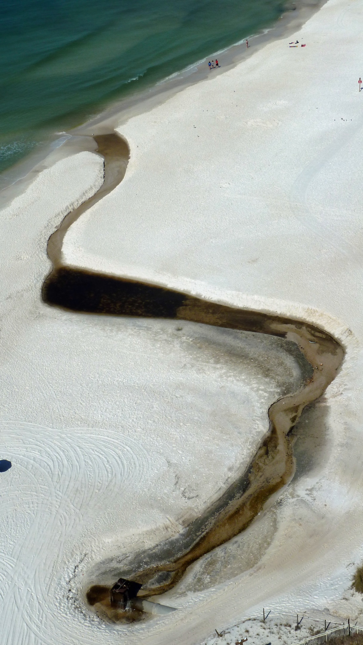 Aerial view of beach showing brackish water of outfall